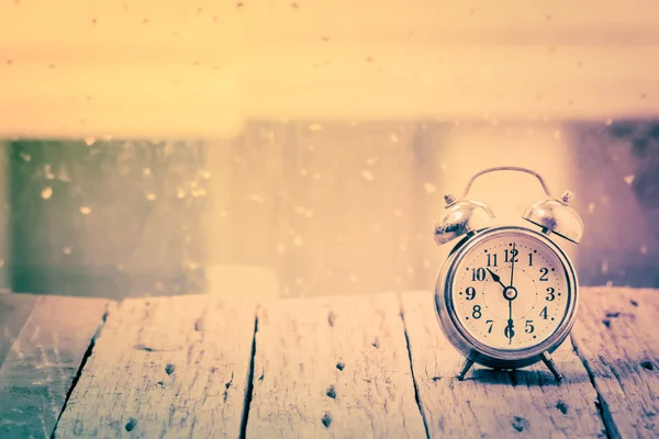 Vintage with alarm clock on wood table beside window