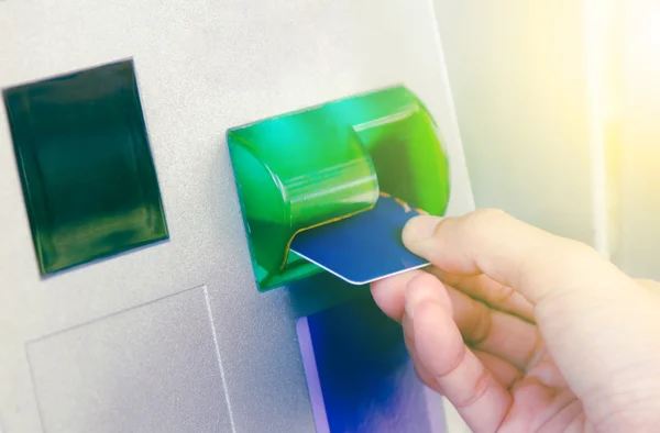 Hand inserting ATM card into bank machine to withdraw money,Hand