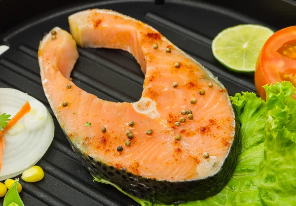 The salmon fish on a pan.