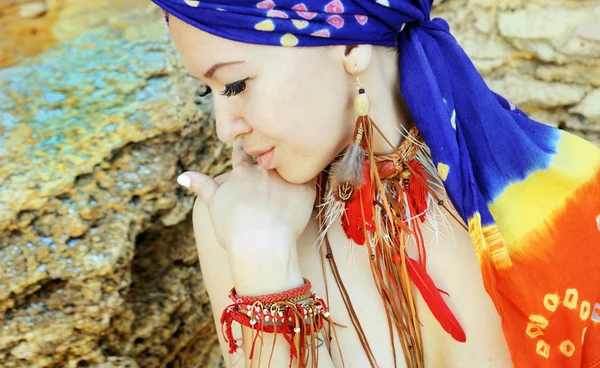 Portrait of a young woman wearing boho chic headband and handmade feathers necklace and earrings