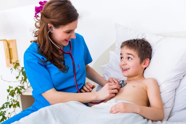 Pediatrician doctor examining little boy\'s heart beat