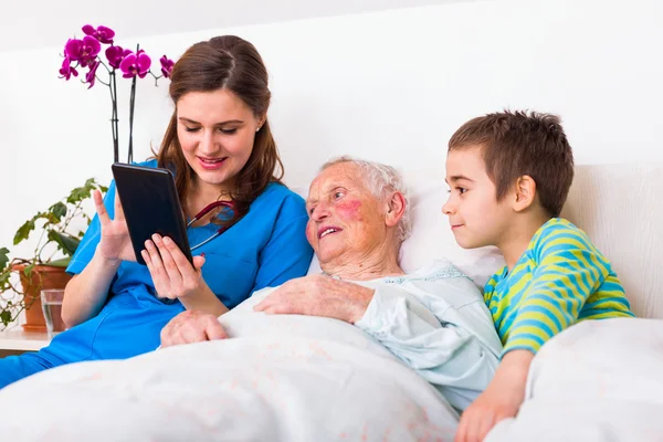 Elderly woman in a nursing home with her grandson and doctor