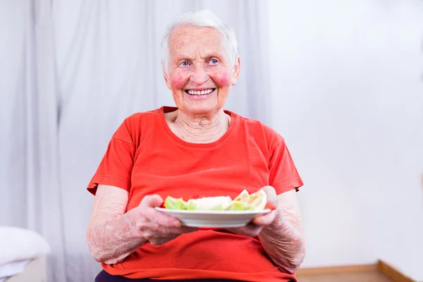 Old woman having a healty meal