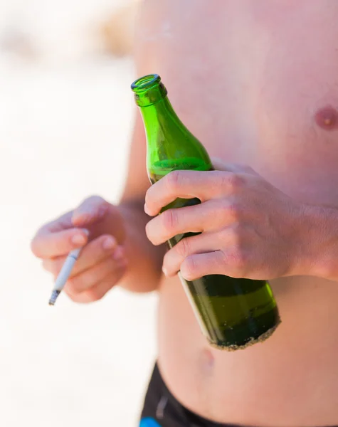 Man holding alcohol and cigarette