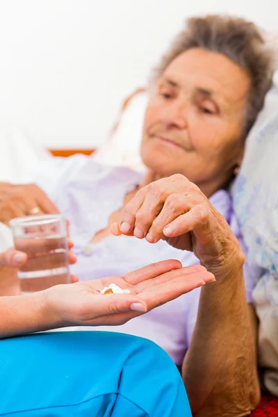 Elderly lady with Alzheimer\'s disease taking pills