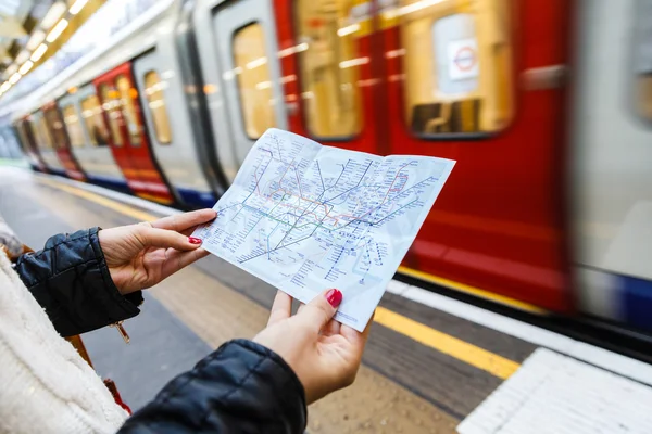Woman holding a map of London \'s underground