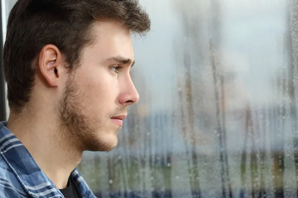 Man longing and looking through window