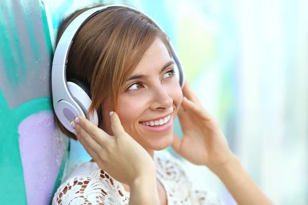 Happy woman with headphones listening to the music