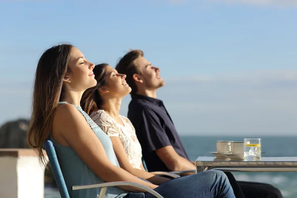 Group of friends breathing fresh air in a restaurant on the beach
