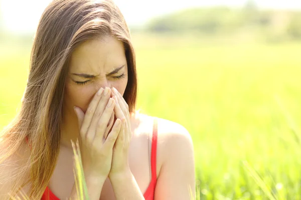 Woman with allergy coughing in a field