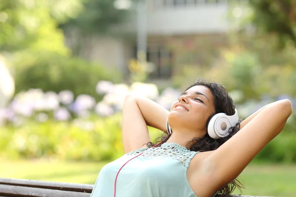 Woman listening to music and relaxing in a park