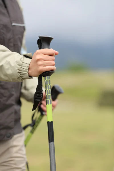 Close up of a hiker hands holding a hiking pole while walking