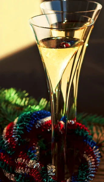 Two flutes of Champagne, Christmas wreath and spruce branch