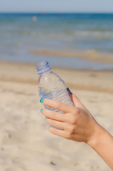 Female hand holding opened bottle of water