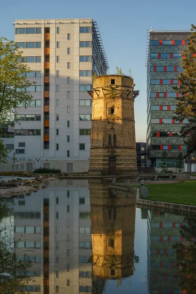 Old abandoned water-tower and modern business building