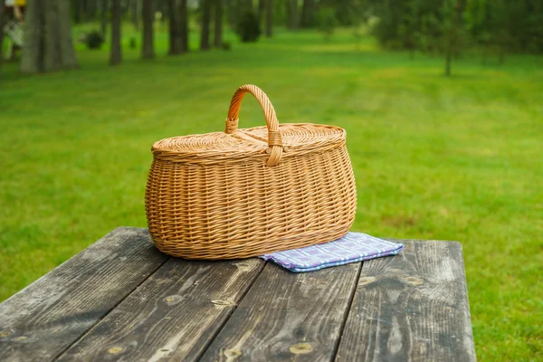 Picnic basket with blue white tablecloth on table