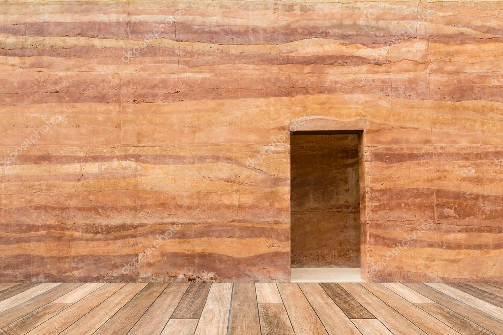 Parete di pietra con porta e pavimento di legno nella parte ...