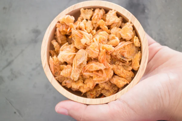 Hand on fried crispy shrimp head