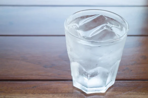 Glass of cold water on wooden table