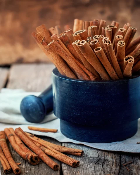 Cinnamon Sticks in a Mortar on Wooden Table