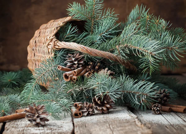 Branches of Blue Fir Tree in a Rustic Basket on Wooden Table