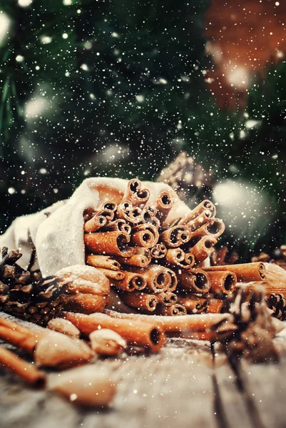 Christmas Sticks of Cinnamon on Wooden Background. Drawn snow