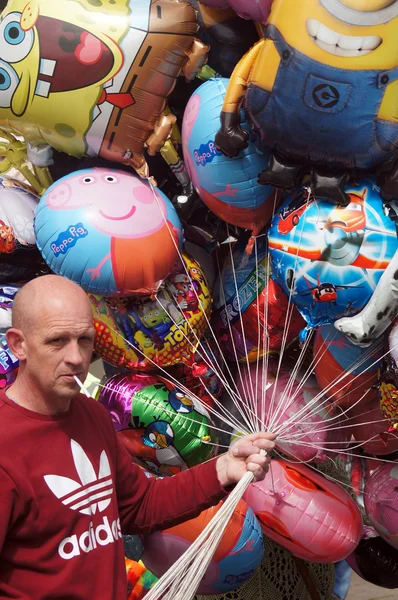 Balloon seller holding colorful balloons