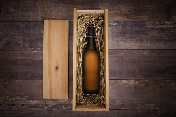 Craft beer bottle in a wooden gift box on a rustic table