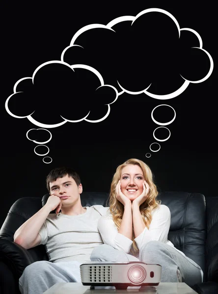 Couple watching a movie or a sport broadcast on a laser projector