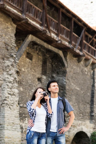 Traveling couple with a medieval building on the background