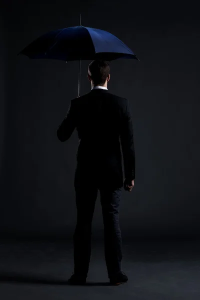 Businessman with blue umbrella