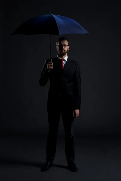 Businessman with blue umbrella