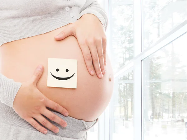 Sticker with smiley on pregnant belly