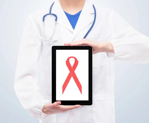 Doctor with tablet and pink ribbon on it on a blank background