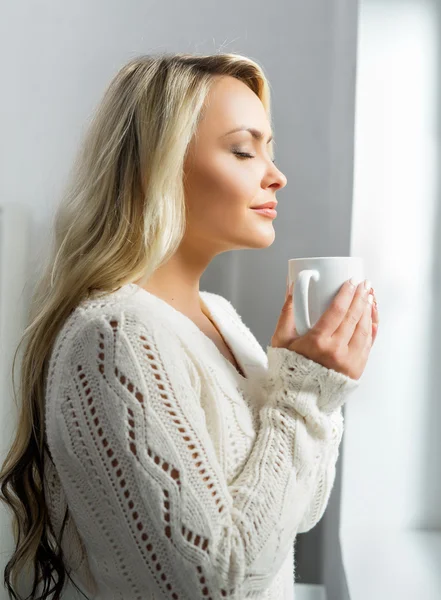 Woman drinking coffee with closed eyes