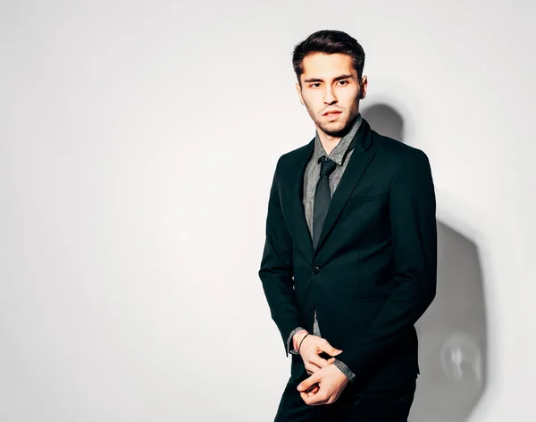 A young man in a modern suit. Indoor. Warm color.