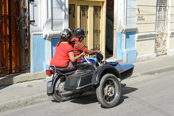 People driving a sidecar bike at Santiago de Cuba