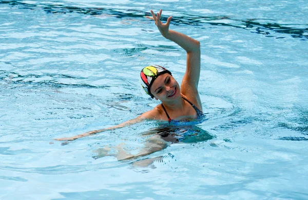 Girl in a pool practicing synchronized swimming