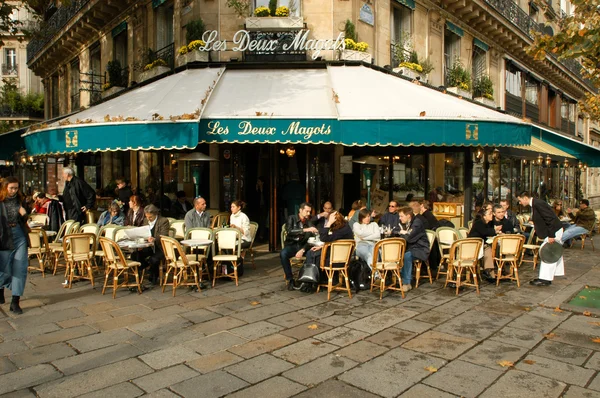 People eating and drinking in a street restaurant of Paris
