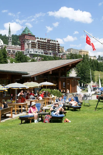 People eating and sunbathing at a restaurant