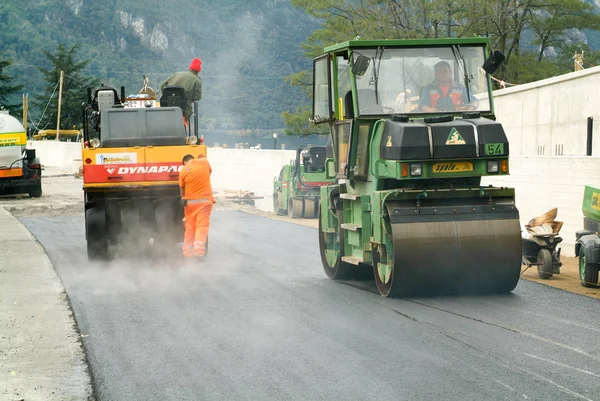 Workers and vehicles during the asphalting of the highway