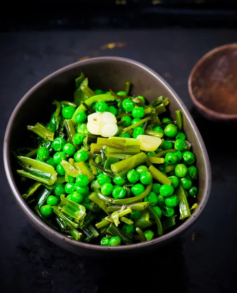 Stewed green peas with fried eggs