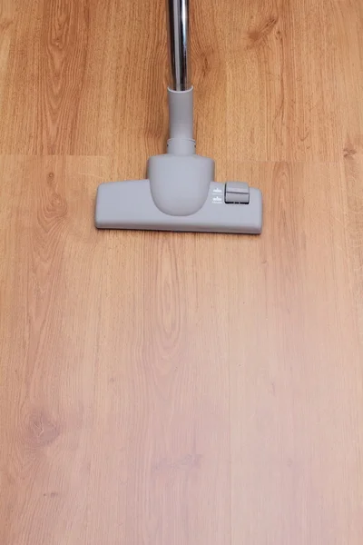 A picture of a vacuum cleaning wooden floor covered