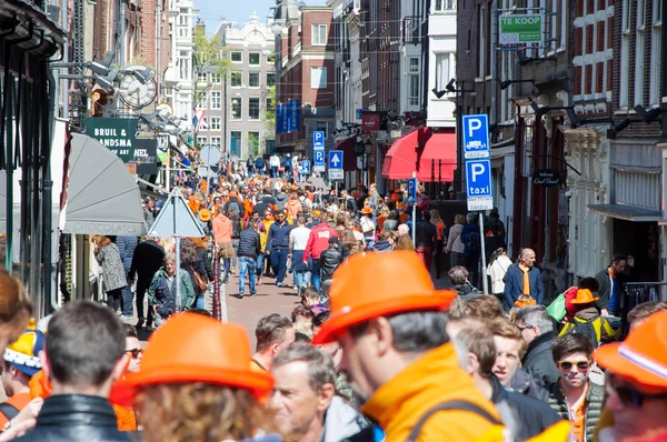 AMSTERDAM-APRIL 27: Crowd of people  in orange on Amsterdam  busy street during King\'s Day on April 27,2015 in Amsterdam.