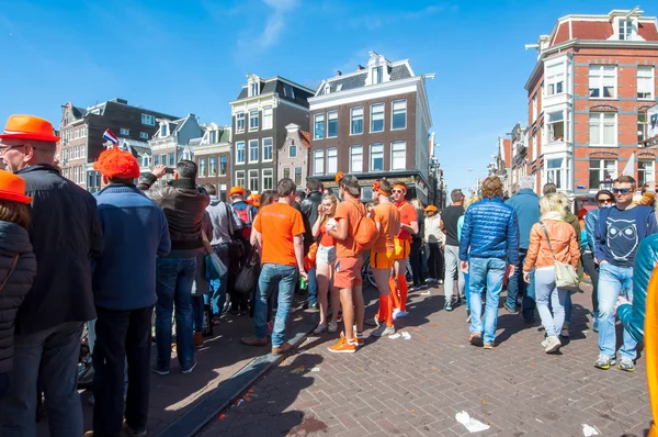 AMSTERDAM-APRIL 27: Locals and tourists celebrate King's Day on the bridge on Singel canal on April 27,2015, the Netherlands.