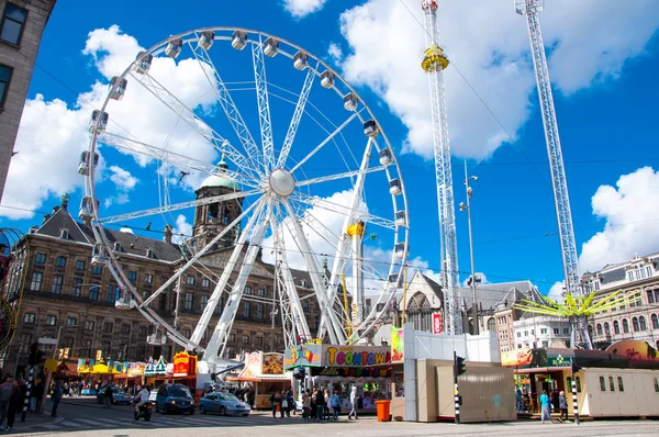 AMSTERDAM-APRIL 30: Dam Square with Ferris wheel and Royal Palace on the background on April 30, 2015 in Amsterdam, Netherlands.