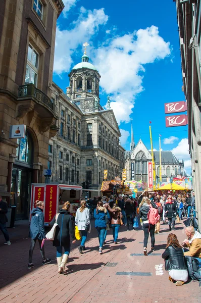 AMSTERDAM-APRIL 30: Crowd of people go shopping in Kalverstraat street, Dam Square is visible in the background on April 30,2015.