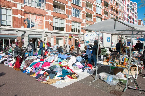 Sale second hand clothing on daily Flea market on Waterlooplein (Waterloo Square), merchants display their bric-a-brac for sale, the Netherlands.