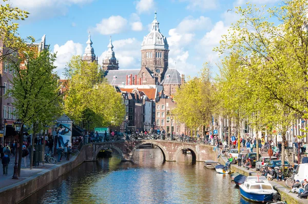Amsterdam-April 30: Red light district, crowd of tourists go sightseeing, the Church of St. Nicholas is visible in the distance on April 30,2015.