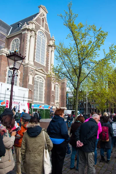 Tourists stand in a queue for tickets to Anne Frank House Museum.